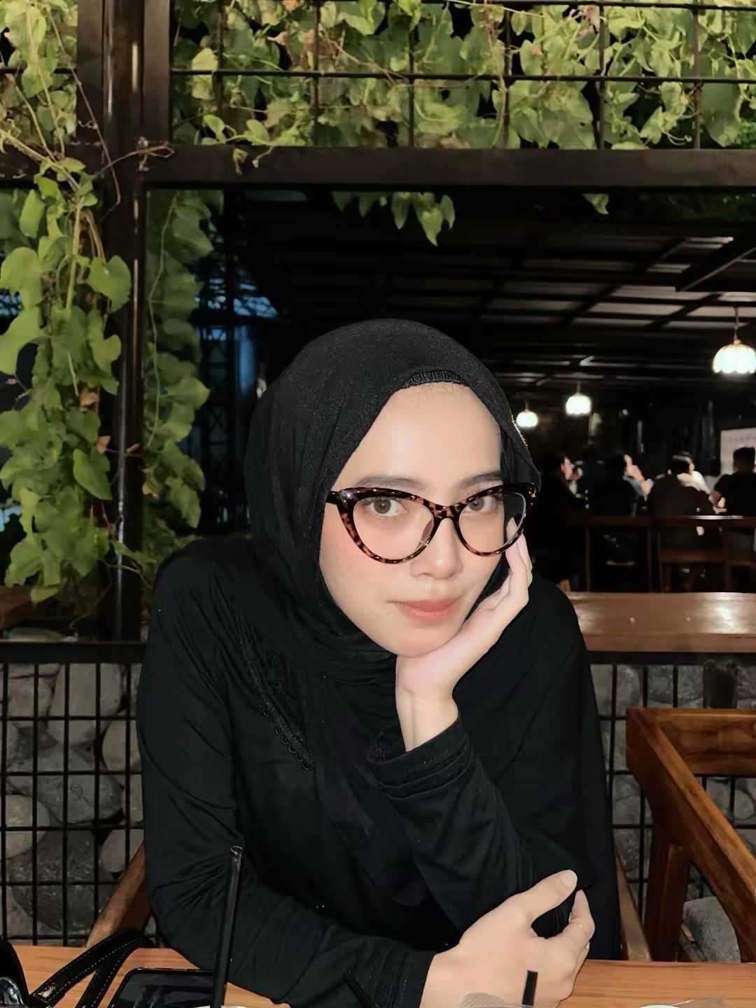 Model utama Azmaza Hijab berhijab hitam dan kacamata estetik